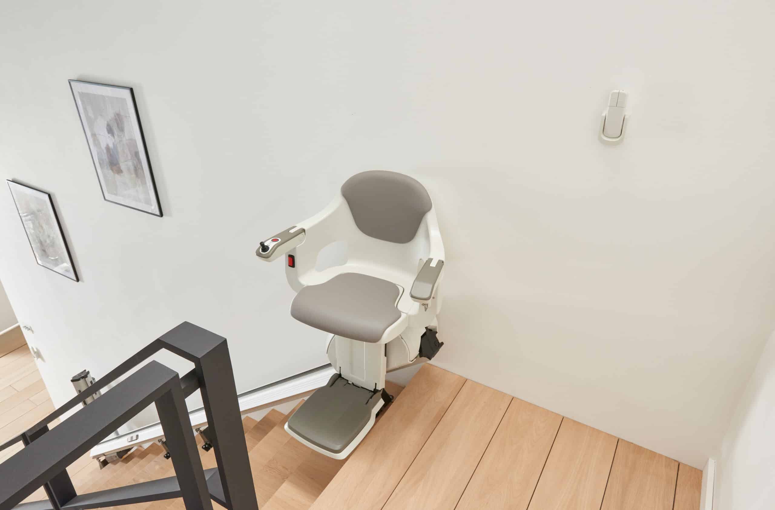 Silla salvaescaleras instalada en parte superior de escalera doméstica